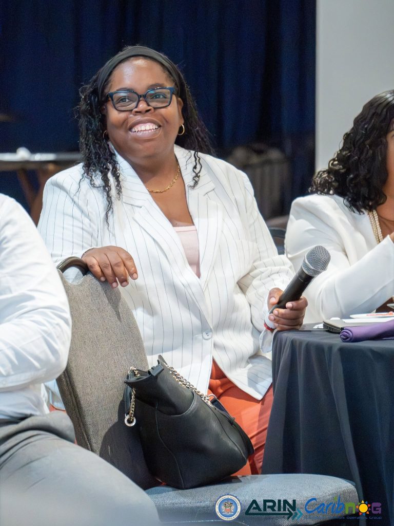A participant smiling as she takes part in the discussion at the ARIN and CaribNOG seminar