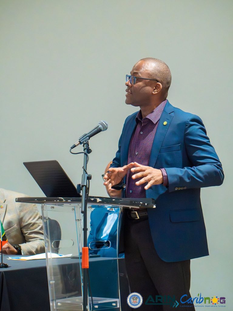 A presenter speaking from the podium at the ARIN and CaribNOG seminar in St. Kitts, October 2026