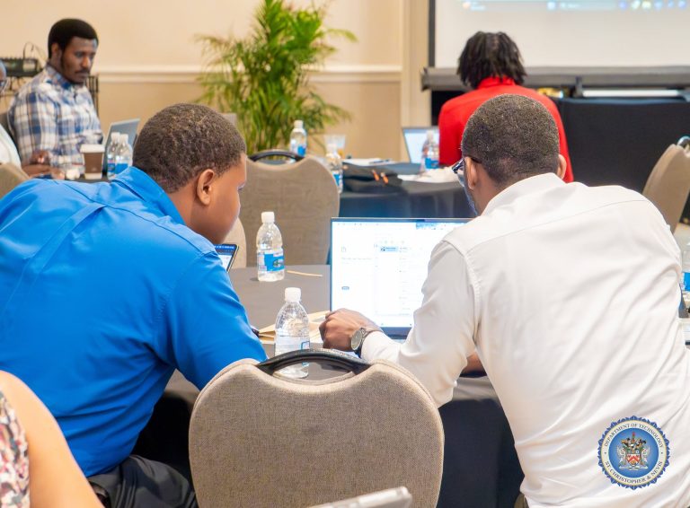 Participants working on laptops at a round table at the cybersecurity workshop in St. Kitts, October 2026
