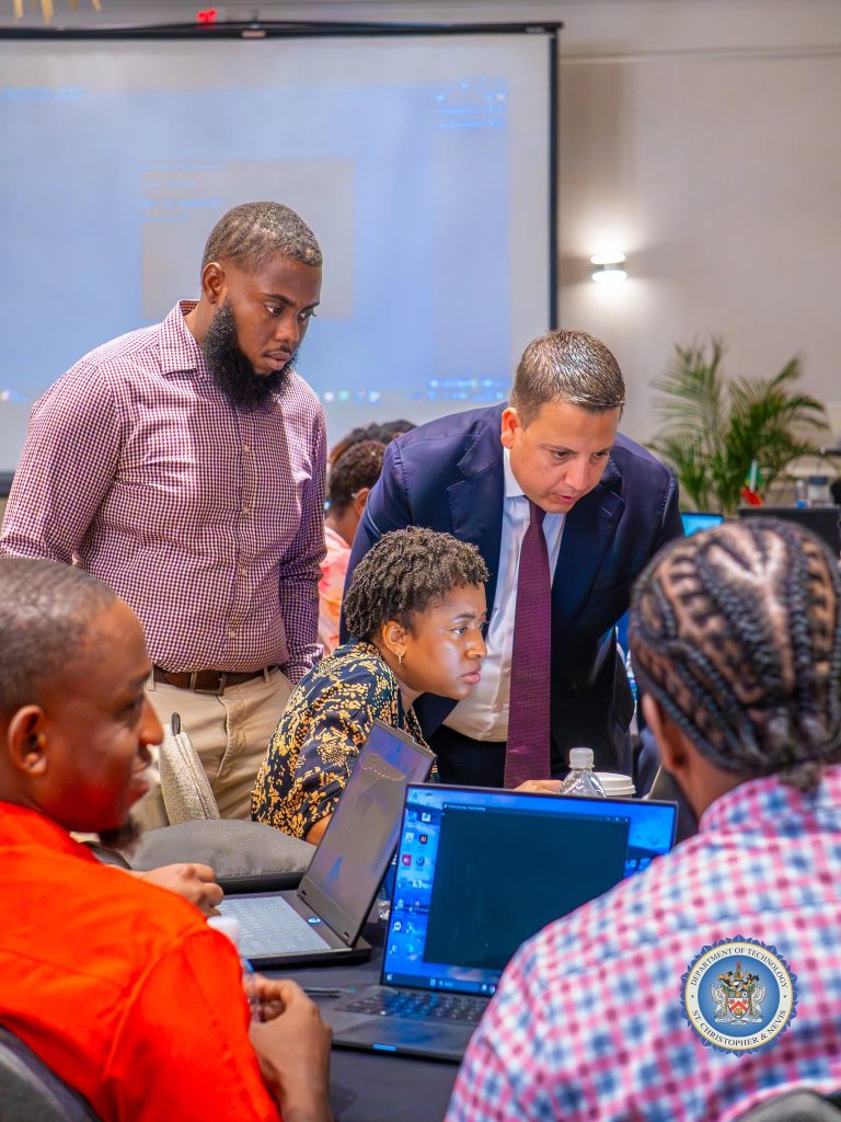 ITU facilitator helping participants at their laptops at the cybersecurity workshop in St. Kitts, October 2026