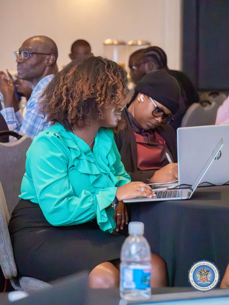 Participants collaborating on laptops during a group exercise at the cybersecurity workshop in St. Kitts, October 2026